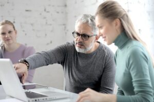 Older worker explaining something to a colleague.