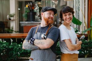 Two young workers outside of a business.