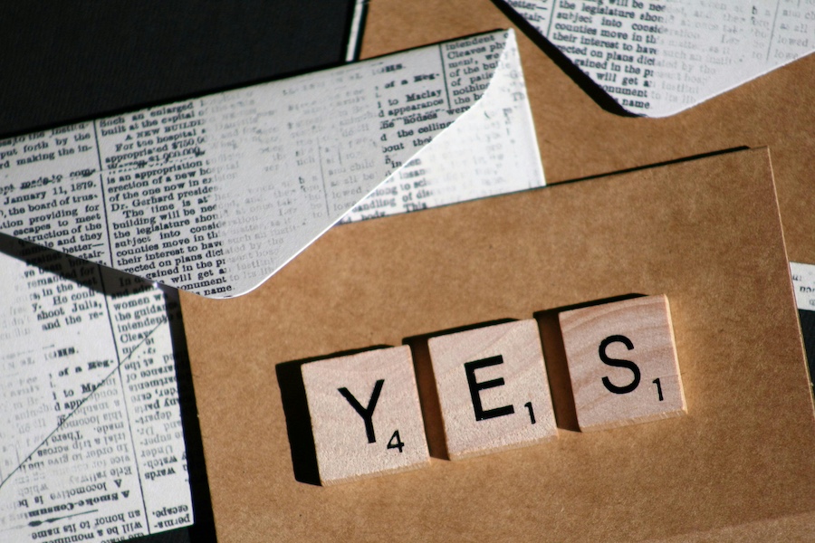 Card with word yes written in tiles.