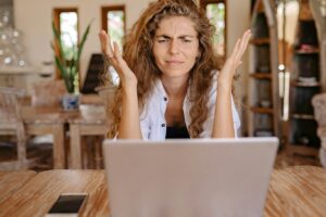 Woman frustrated and looking at a laptop.