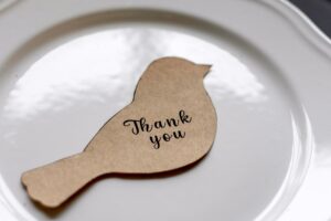 Plate with a paper bird that says thank you