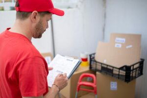 Worker in uniform looking over logistic information.