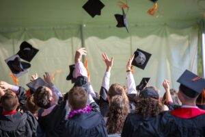 A group of recent graduates throwing their caps in the air.