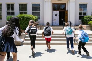 Back-to-school kids running into school.