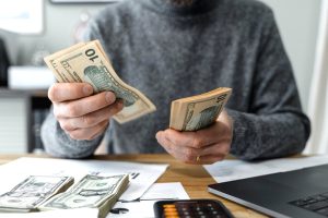 Person counting money at a table.